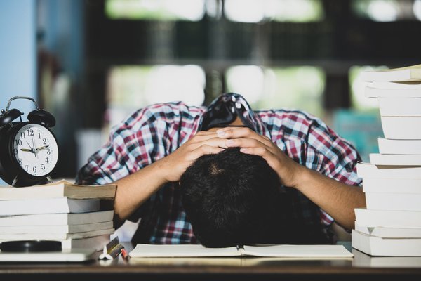 educational-conept-tired-student-library-scaled